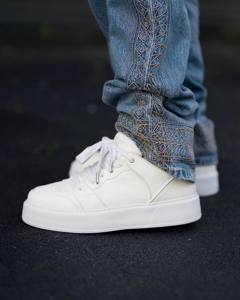 witte sportschoenen voor heren met jeans