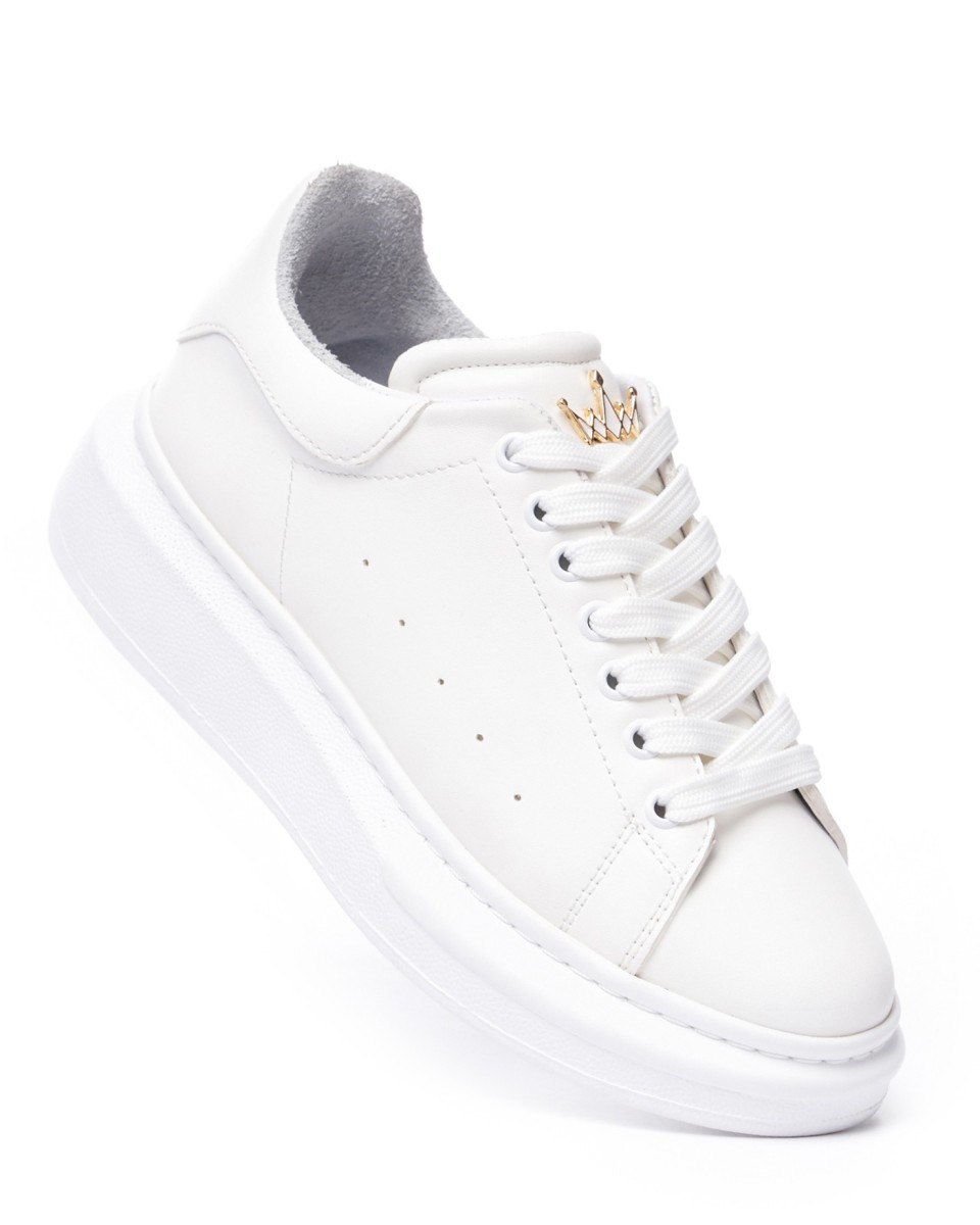 Zapatillas chunky blancas con corona dorada sobre fondo blanco